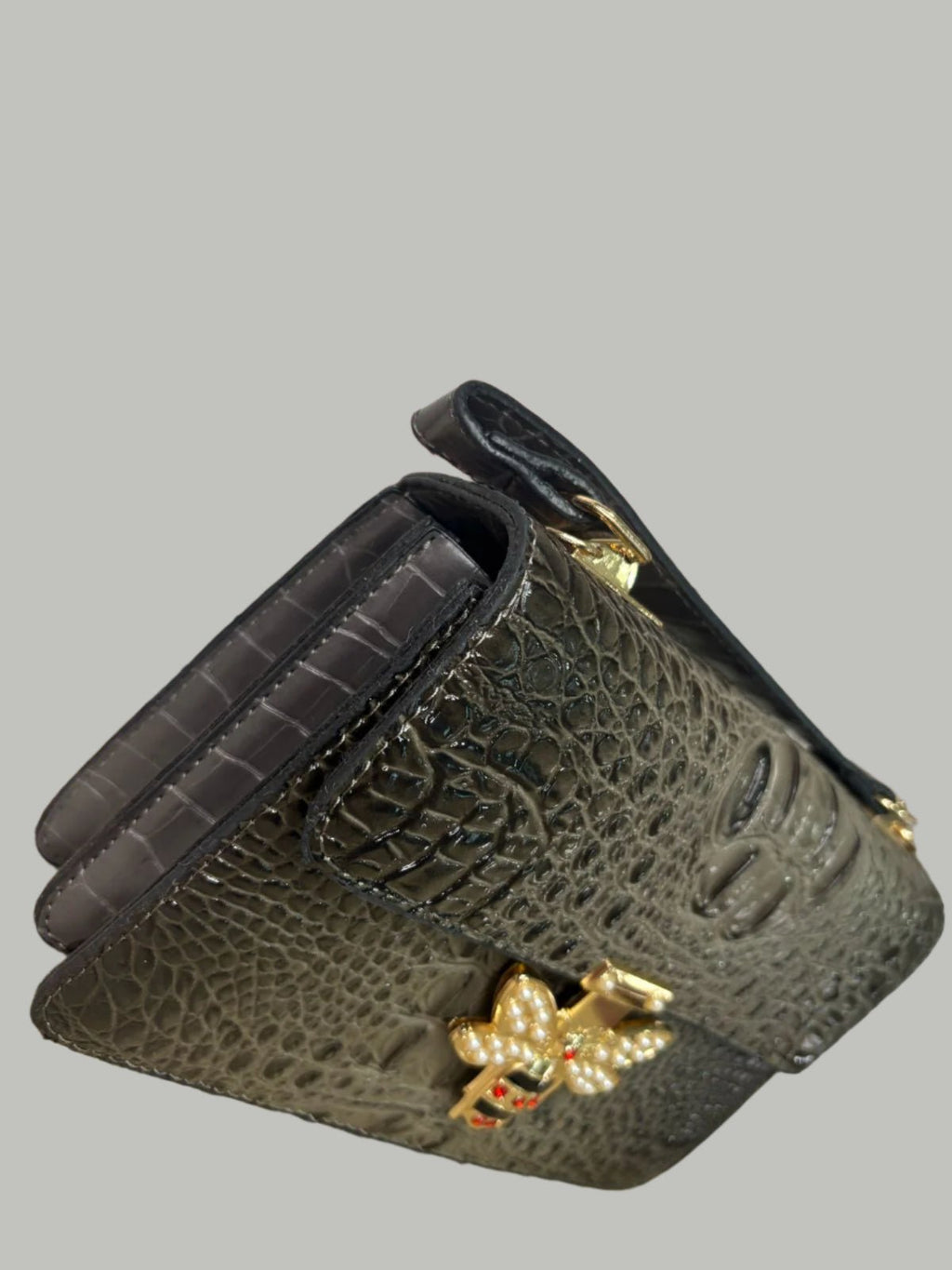 Black textured leather wallet with a decorative clasp.