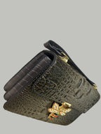 Black textured leather wallet with a decorative clasp.