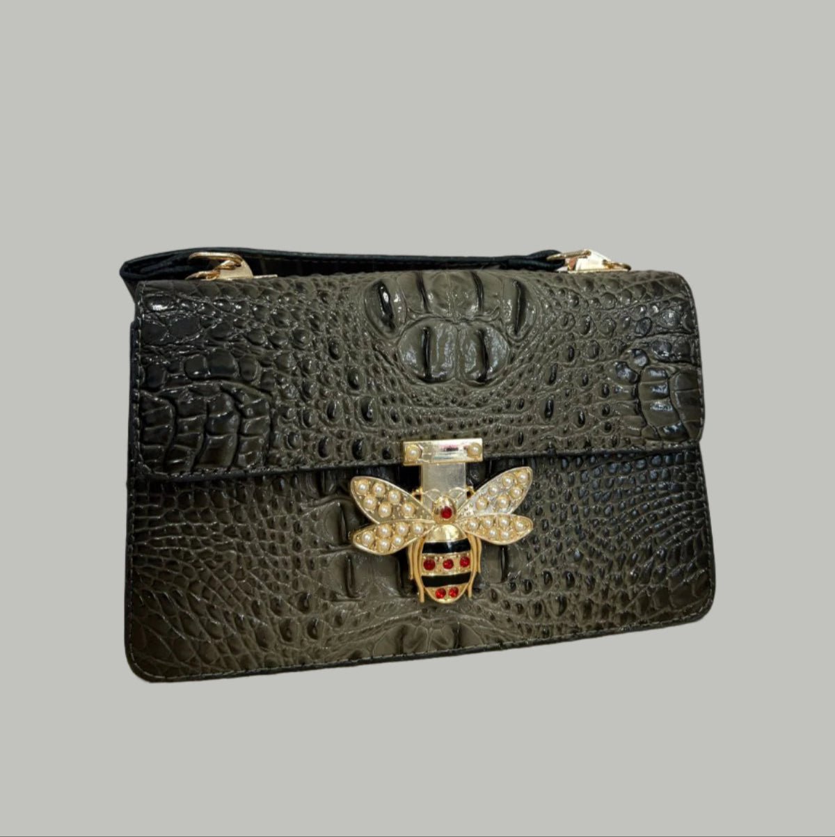 Black textured handbag with bee emblem on a light background