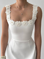White bridal dress with floral and pearl details on the bodice against a plain background.