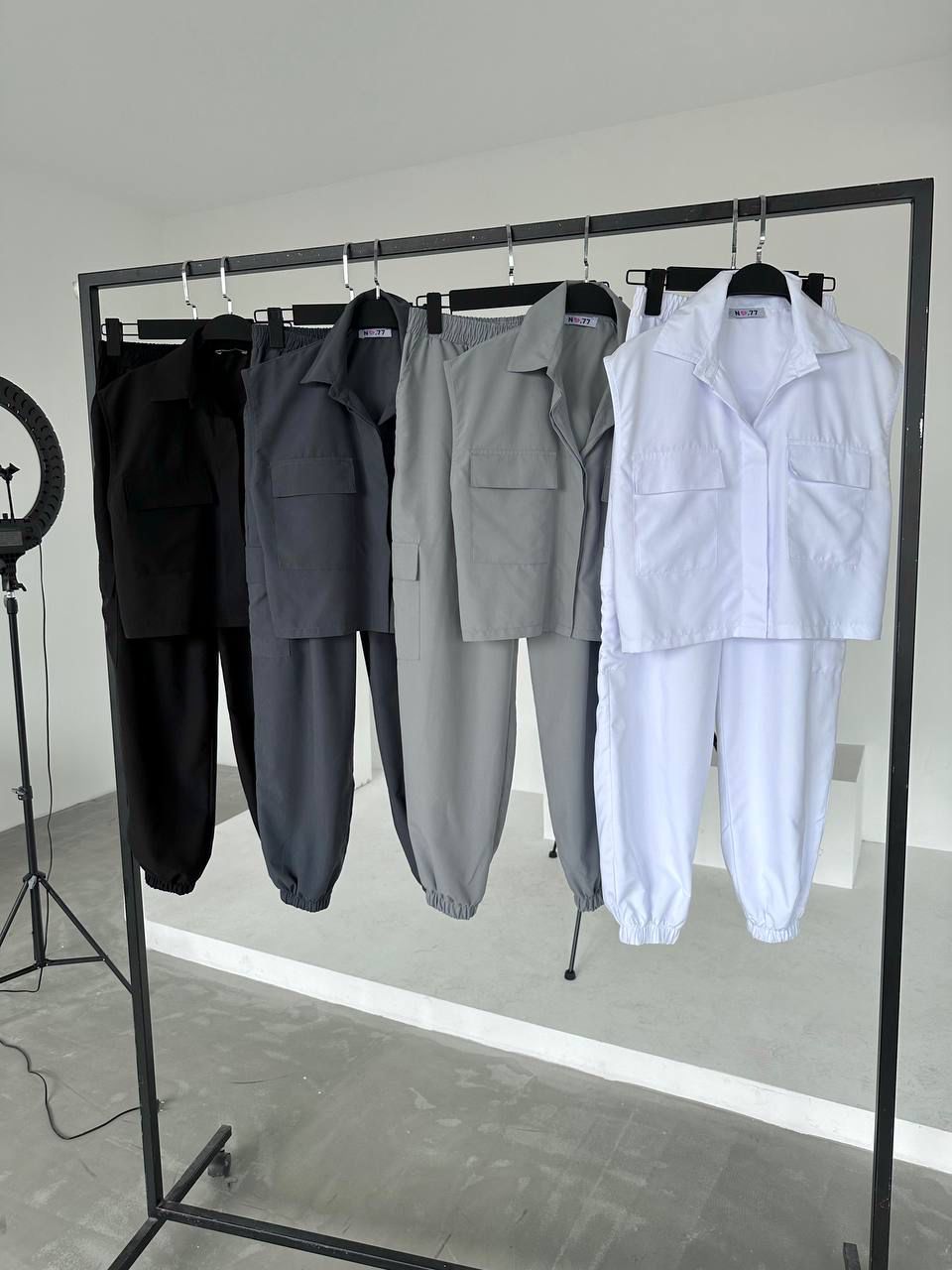 Four pieces of clothing on a rack against a neutral background