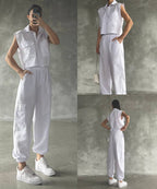 A Woman wearing a white sleeveless cargo jumpsuit with pockets, paired with white sneakers and a watch.