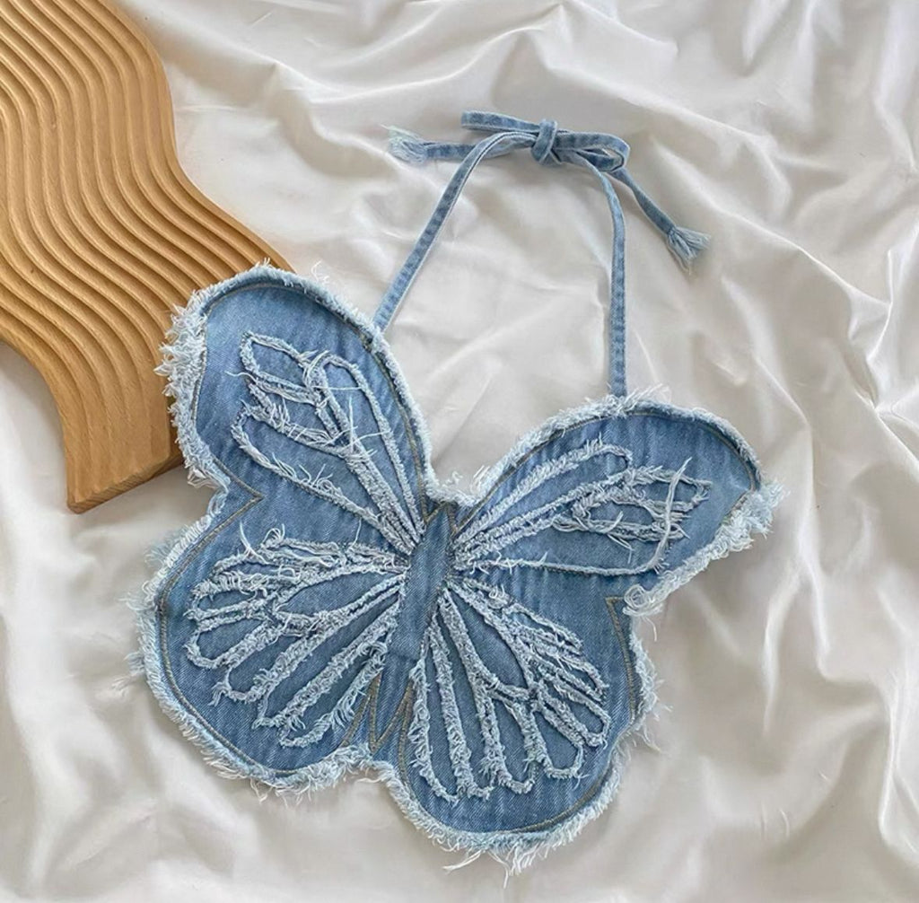 Denim butterfly-shaped bag on a white fabric background