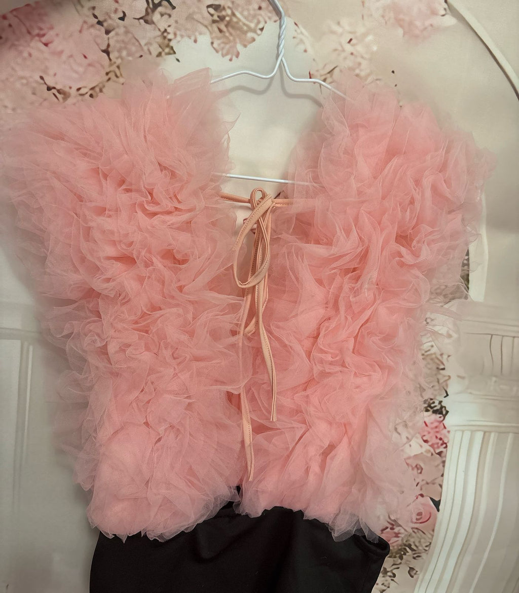 Pink bodysuit on a hanger against a floral wallpaper background