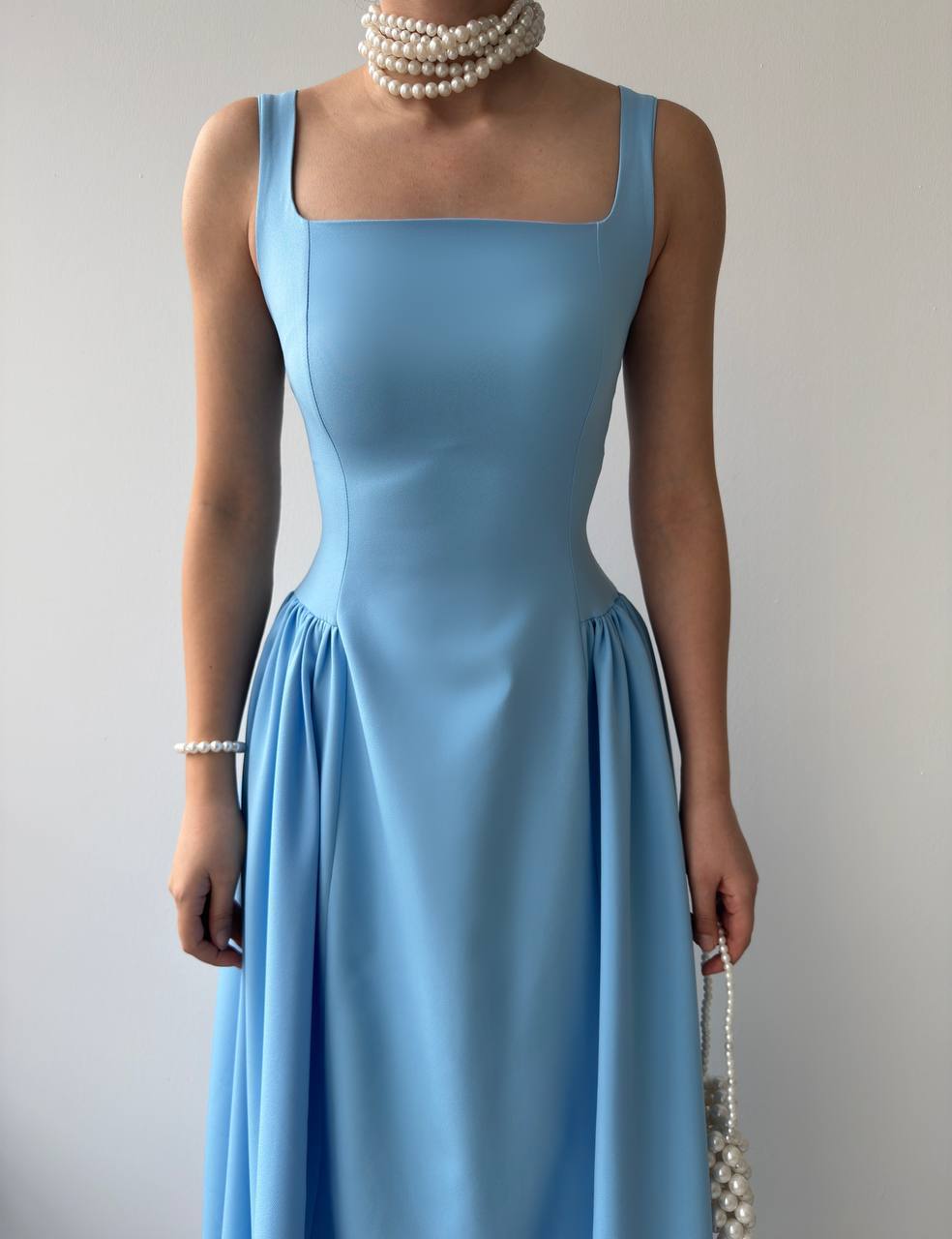 Blue dress worn by a model against a plain background.