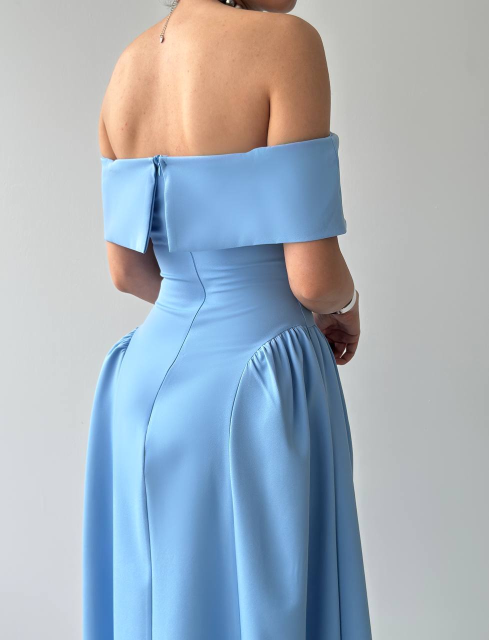 Light blue off-shoulder gown on a plain background