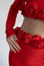 Red outfit with floral details on a plain background