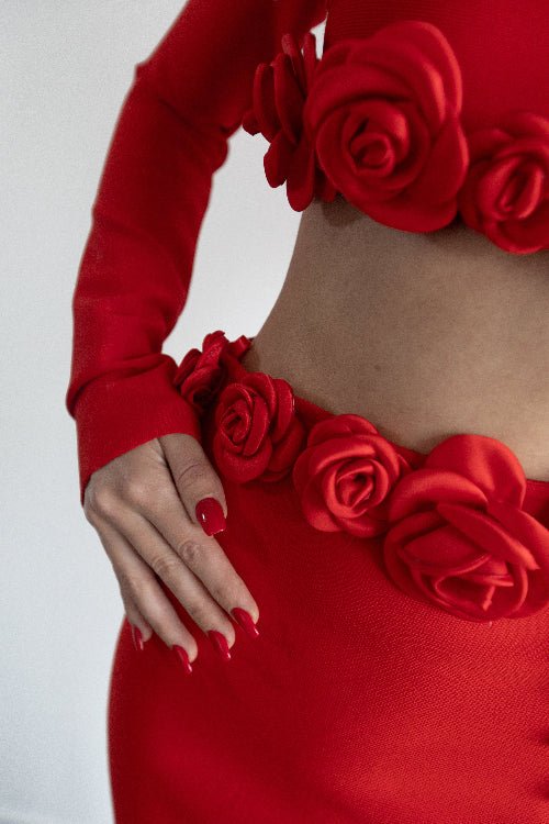 Red outfit with floral details on a plain background