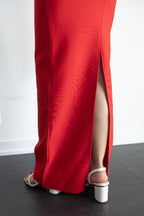 Red evening gown with a high slit on a white background