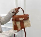 Person holding a brown and beige handbag against a light background