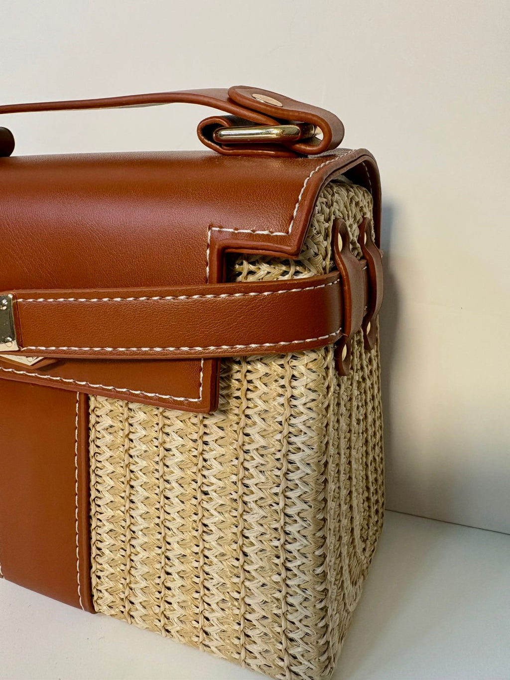 Brown leather and wicker handbag on a light background
