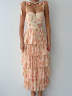 A floral print dress with ruffled layers and a sweet neckline, in a beige background.