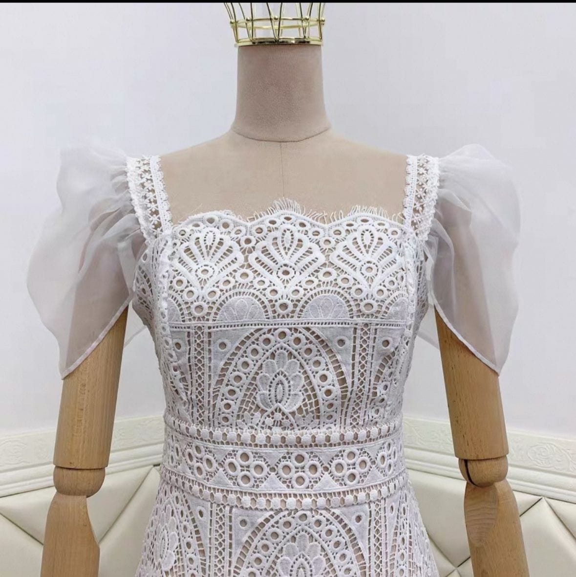 White lace dress on a mannequin against a white background