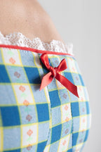 Checkered dress with a red bow on a plain background
