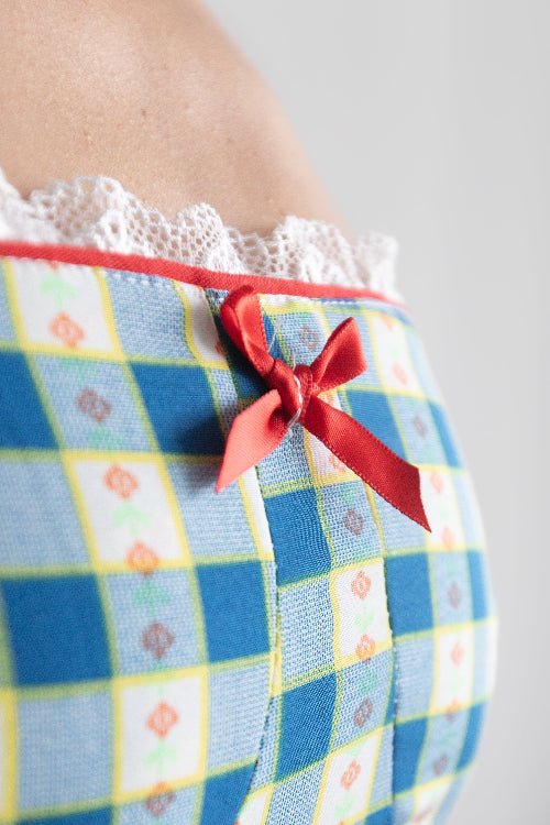 Checkered dress with a red bow on a plain background