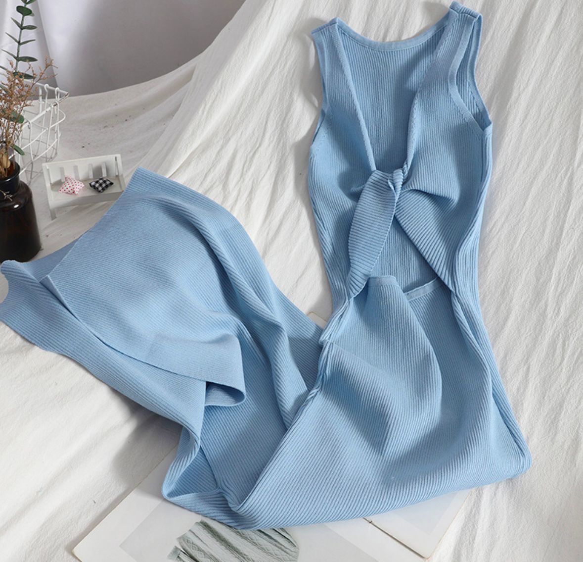 Light blue sleeveless dress with a knot detail on a white surface