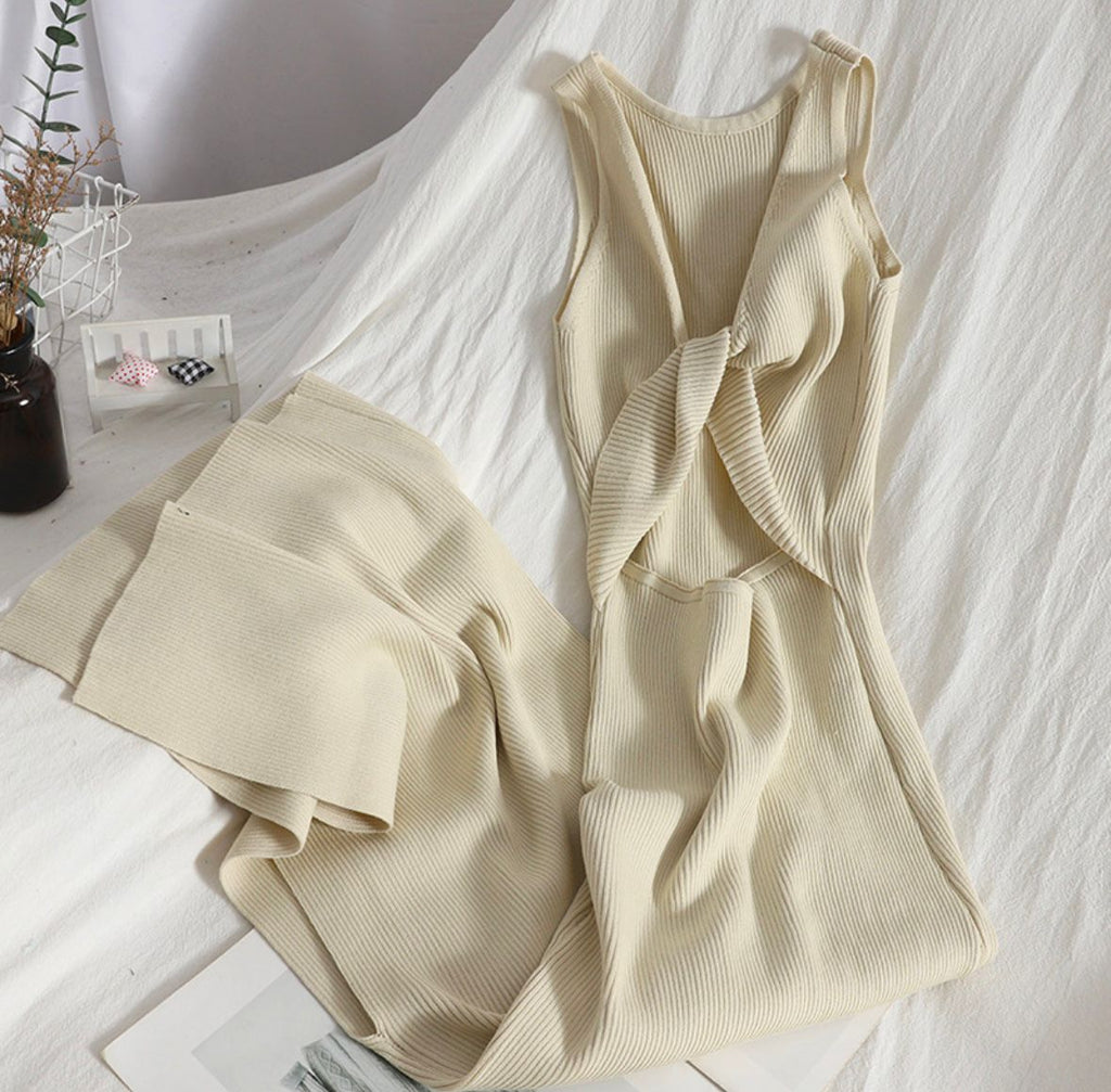 Beige sleeveless top and pants on a white surface with a blurred indoor background