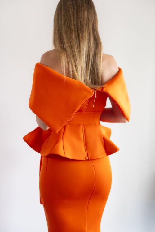 Orange off-shoulder dress with ruffled details on a white background