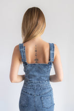 Woman wearing a denim dress with a plain background